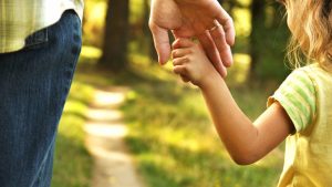 the parent holds the hand of a small child; Shutterstock ID 334181882; user id: 14504460; user email: tougao@ksjgs.com; user_country: China; discount: 5%